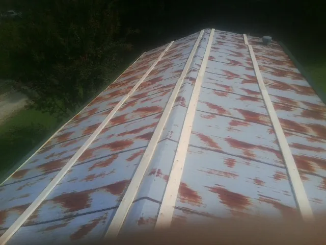 Rusted metal roof panels with new wood purlins before replacement — Storm Damage Roof Repair in Madras by Roofing Brothers