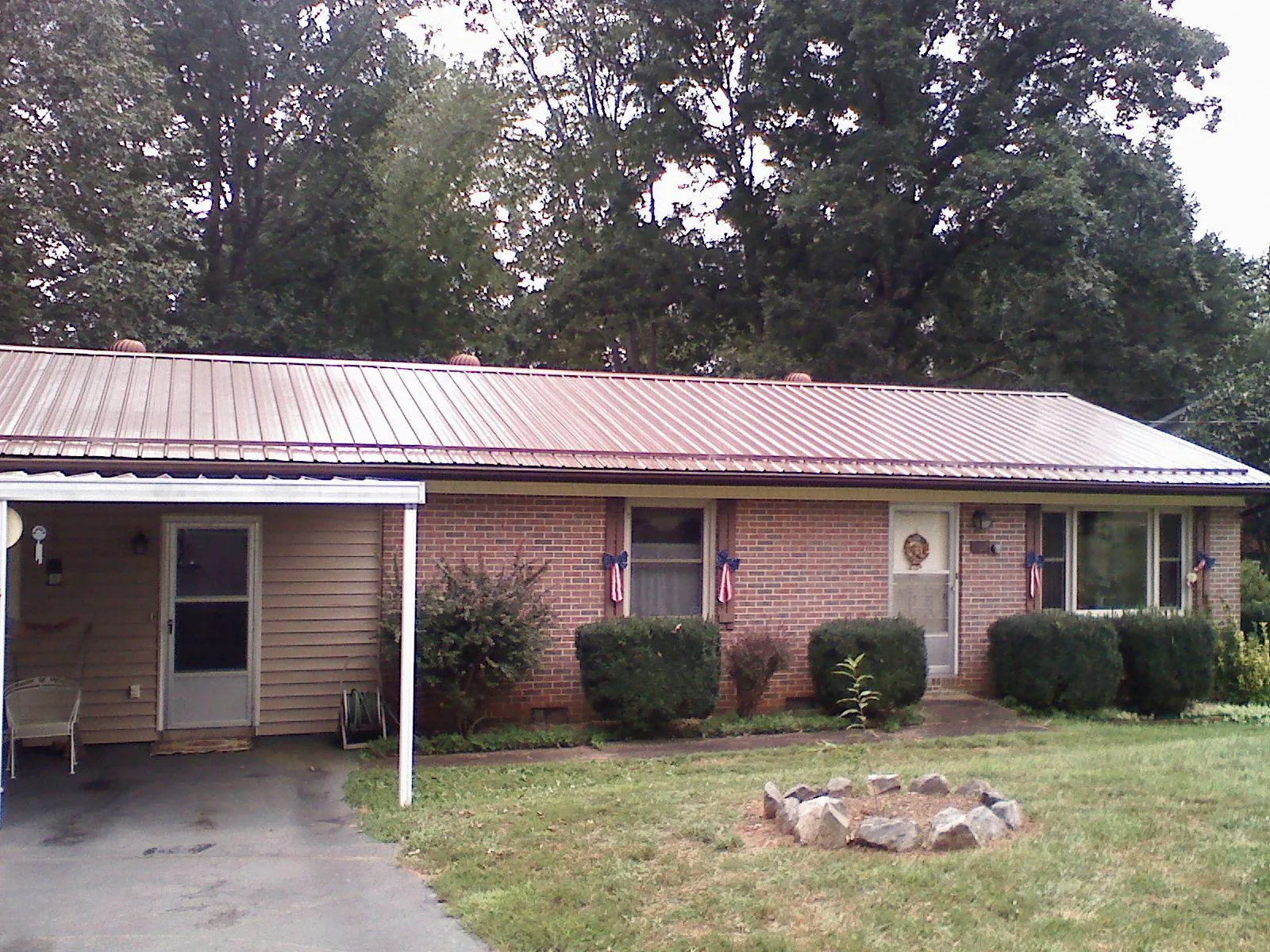 Bronze metal roof and carport on a brick ranch home — Roof Repair work by our crew in Madras