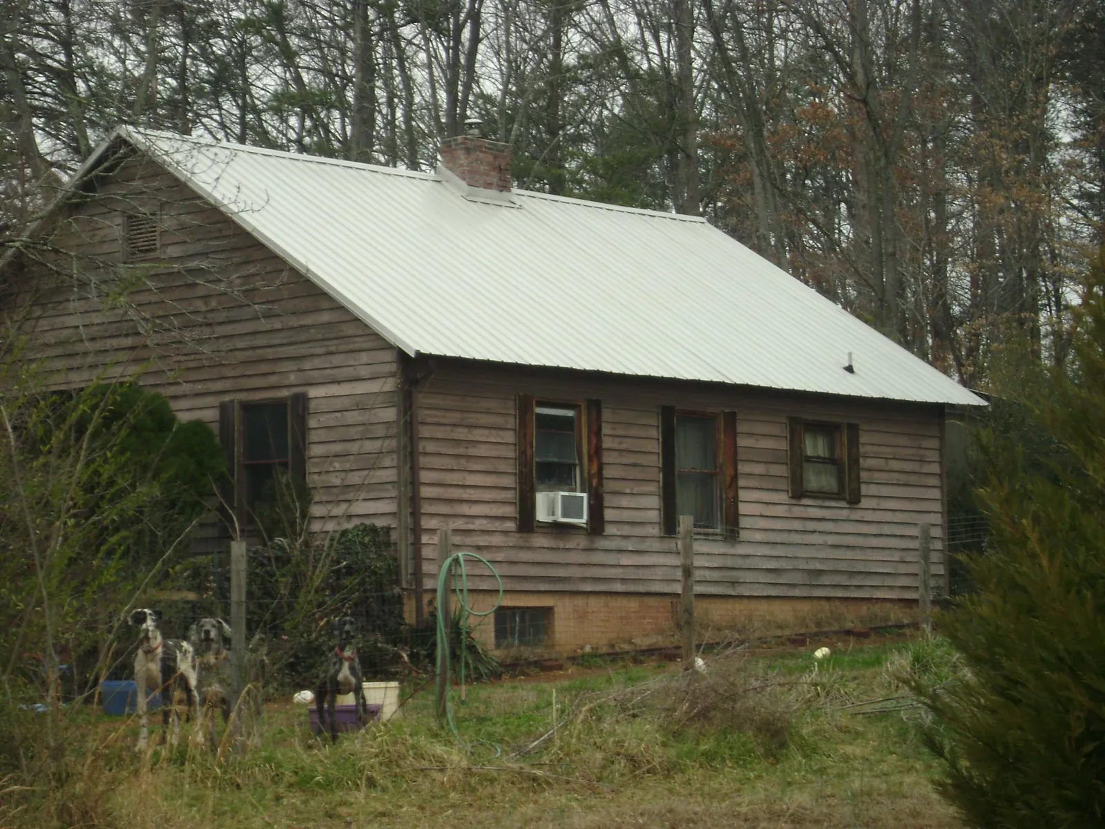 White metal roof on an old wood sided farmhouse, from a Metal Roof Installation job in Madras